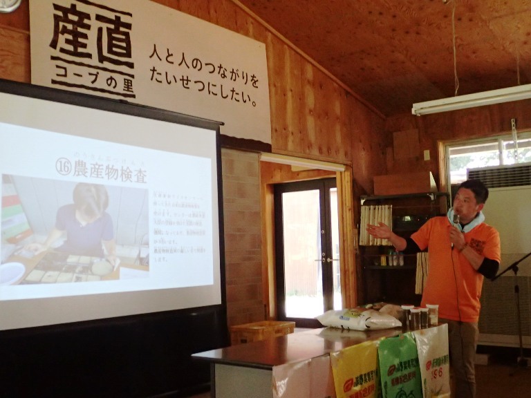 多古町旬の味産直センターで行われている農産物検査の様子を説明する、鎌形専務理事。