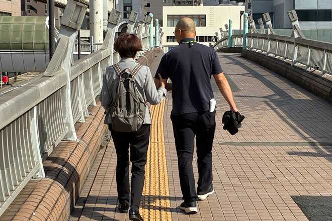 職員が最寄り駅から会場までご案内している様子