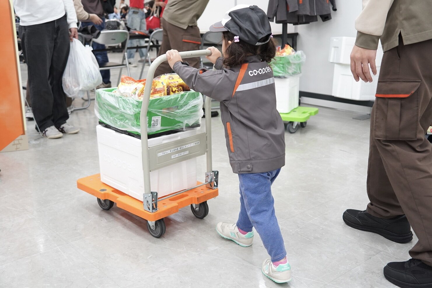 子どもたちが台車で荷物を運び、コープデリ宅配のお仕事を体験しました